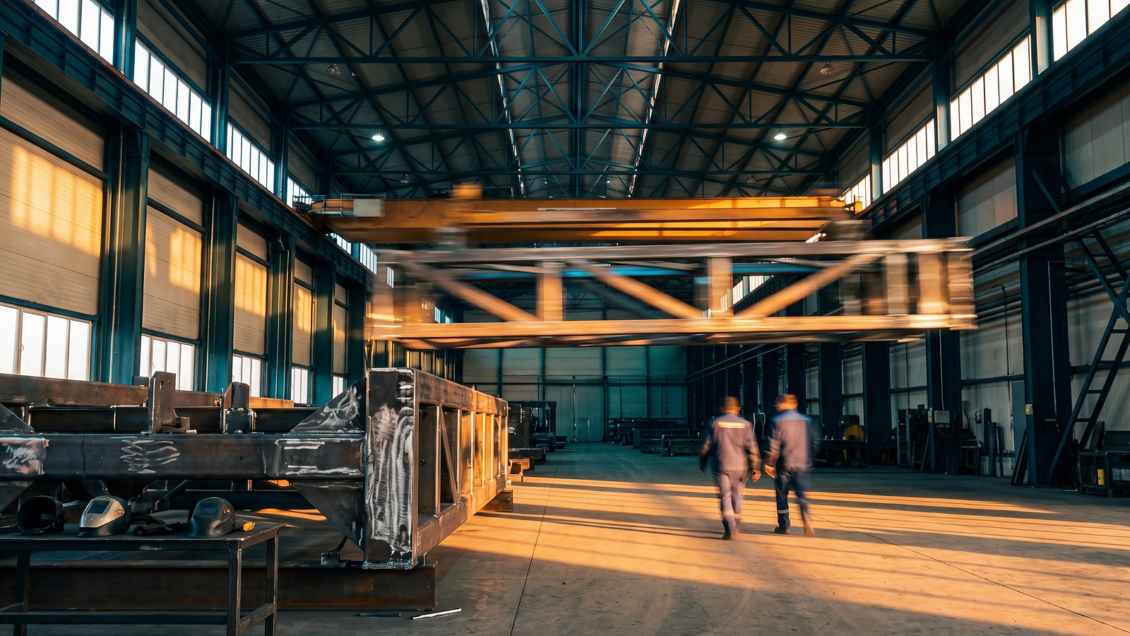 Industrial workshop with an overhead crane and a working team